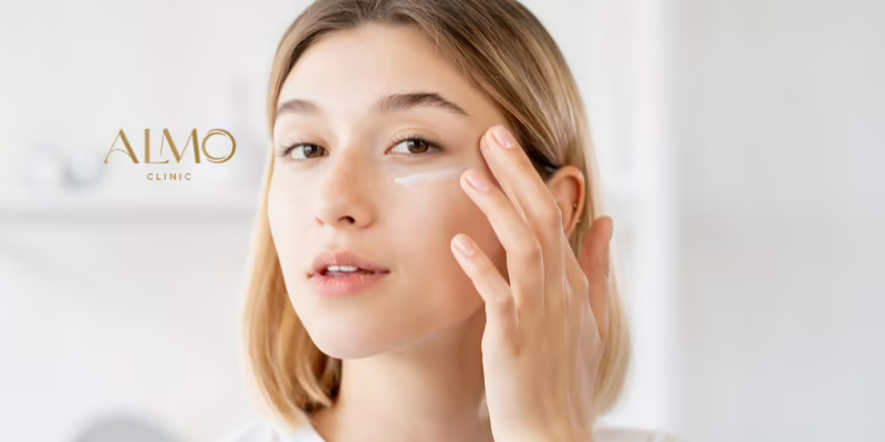 Types of dark circles under the eyes and how to treat them Woman touching the skin under her eye, with a line of eye cream over the dark circle area